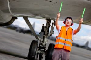 Air traffic controller holding light signs at the airport